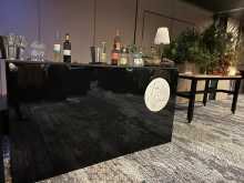 Black acrylic bar unit 2000mm w x 600mm d x 1100mm h The top is Wenge laminate, with a middle shelf.